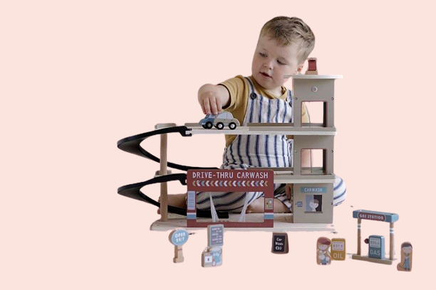 Zēns spēlējas ar daudzlīmeņu koka rotaļlietu garāžu – attīstoša rotaļlieta bērniem no 3 līdz 4 gadiem