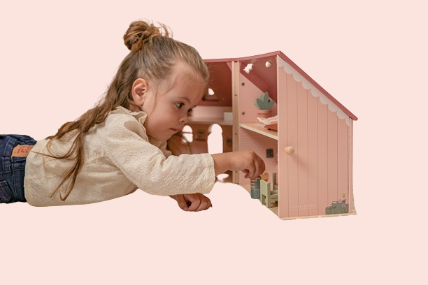 Meitene spēlējas ar rozā koka leļļu māju – attīstoša un radoša rotaļlieta bērniem