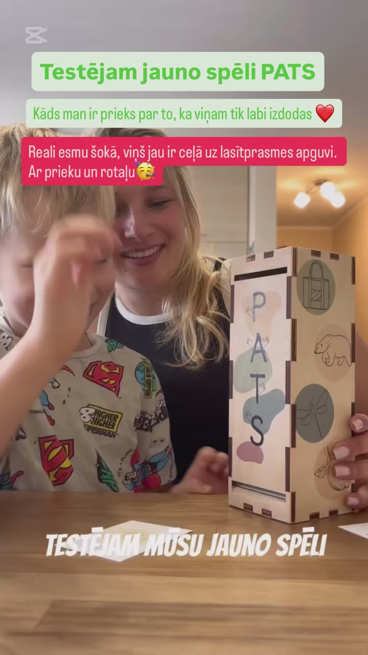 Bērns spēlē koka spēli PATS, mācoties lasīt ar kartītēm un attēliem, izgatavota Latvijā