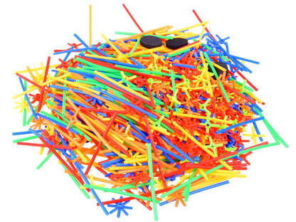 Bērns būvē krāsainu konstrukciju no salmiņu komplekta, attīstot radošumu un iztēli.